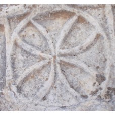 Flower-like, four-pointed solar wheel engraved on a marble